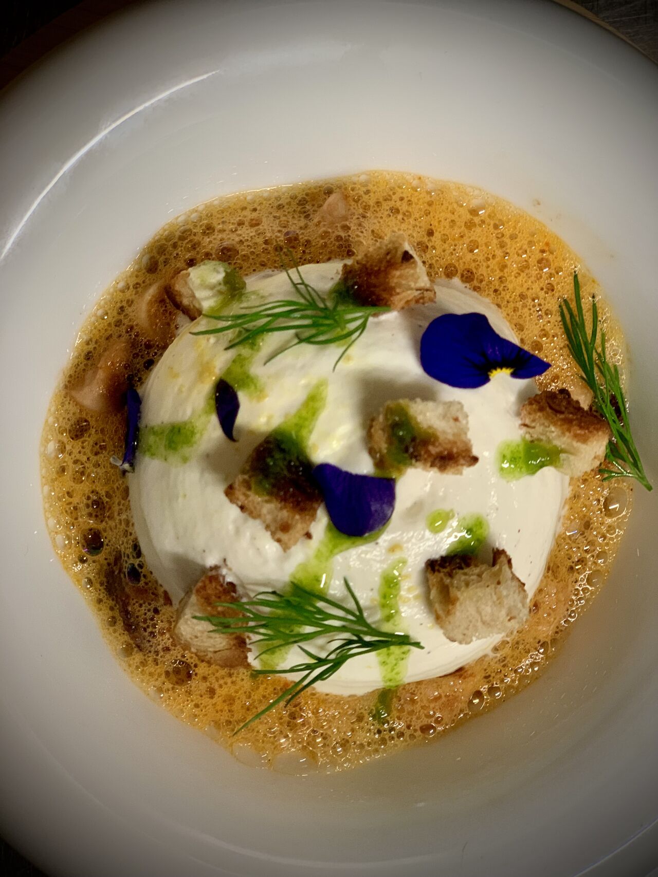 Émulsion crémeuse, croûtons, aneth et fleurs comestibles