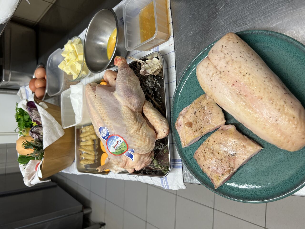 Mise en place en cuisine : poisson, volaille et produits frais sur le plan de travail