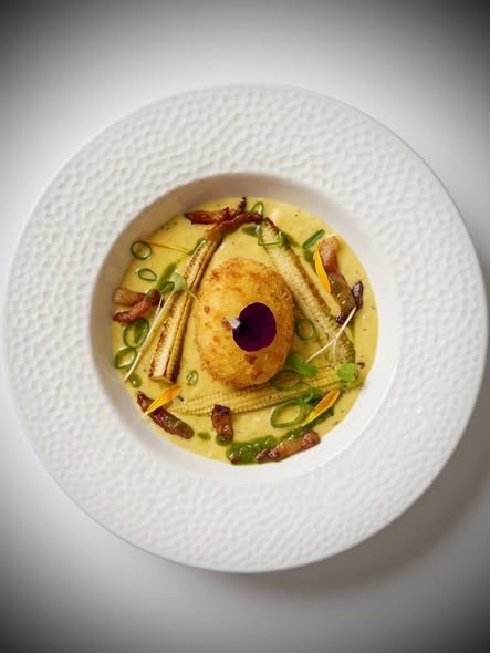 Œuf mollet frit sur un crémeux de maïs à l’ail des ours, maïs grillé et guanciale